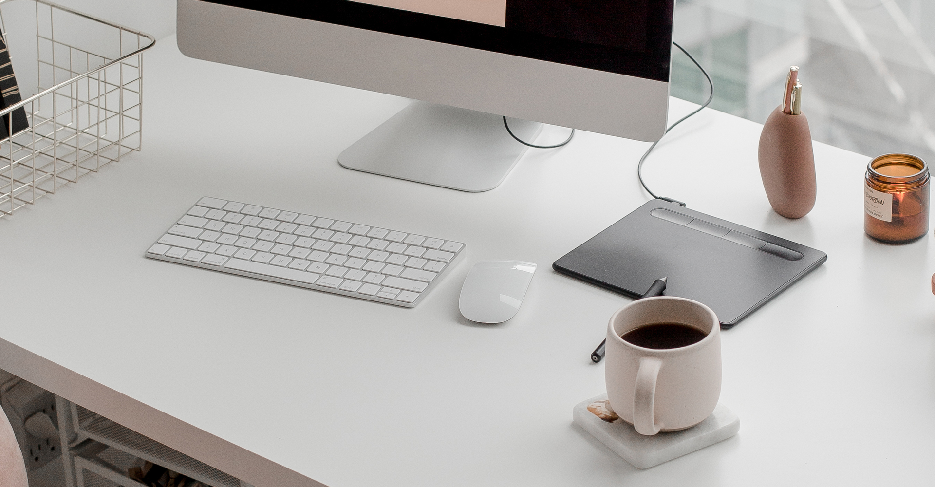 Desk with keyboard, a cup of coffee, computer.